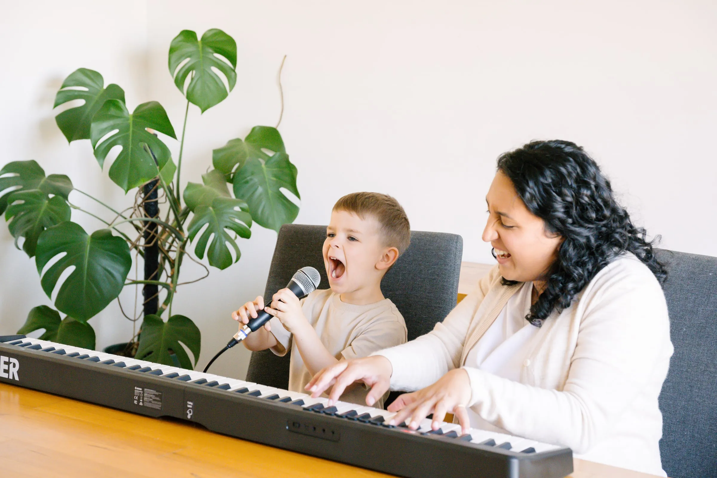 Maria and a young boy singing together at the keyboard
