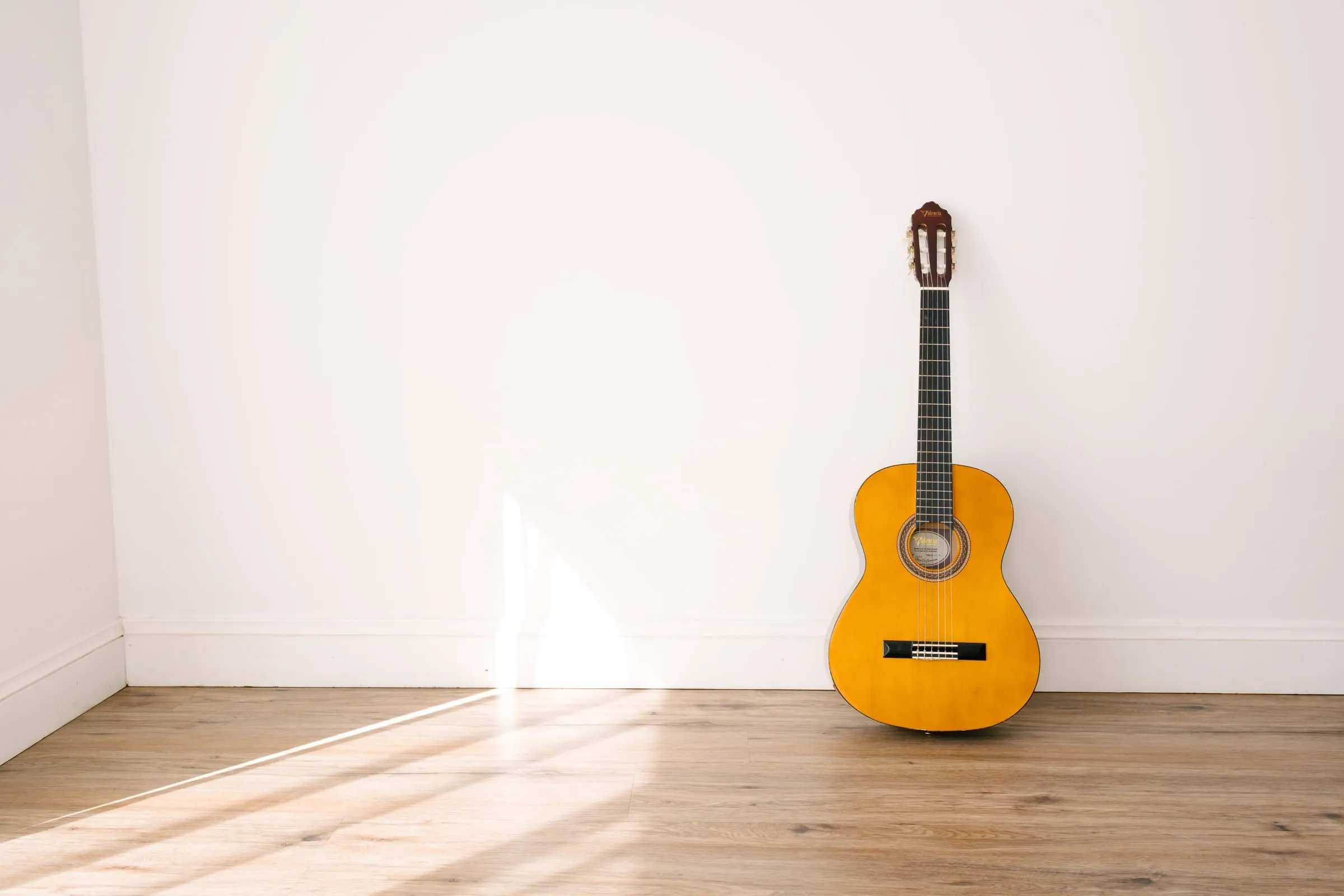 A guitar resting in soft window light