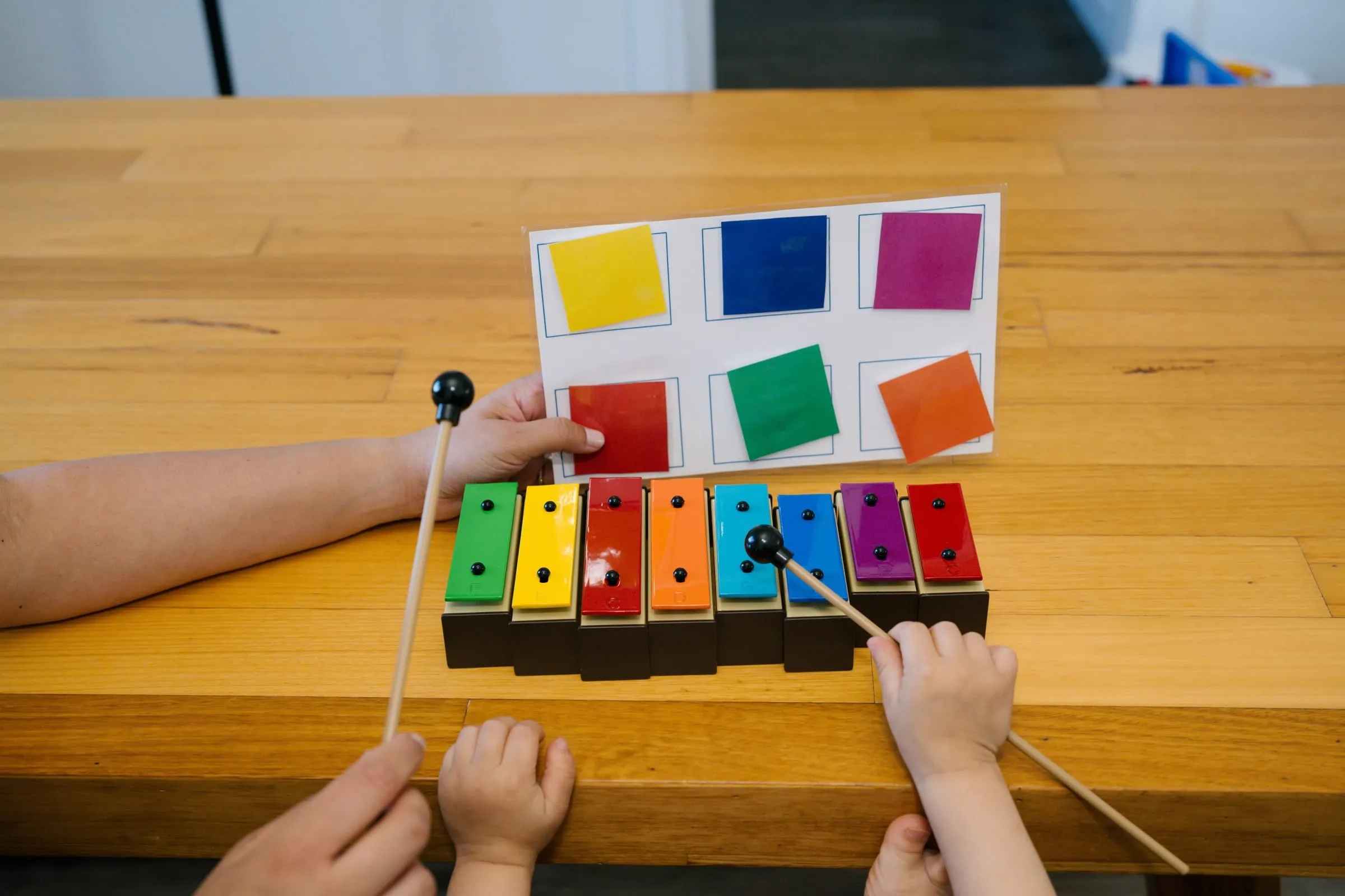 Small hands playing a colourful xylophone